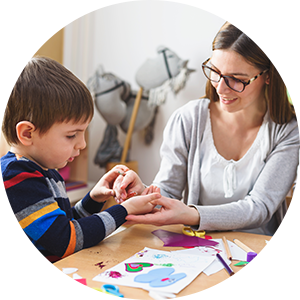 A child and an educator at a table