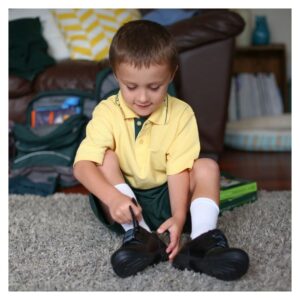 Young boy puts on shoes