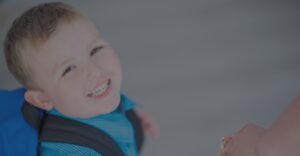 Young boy smiles walking into school