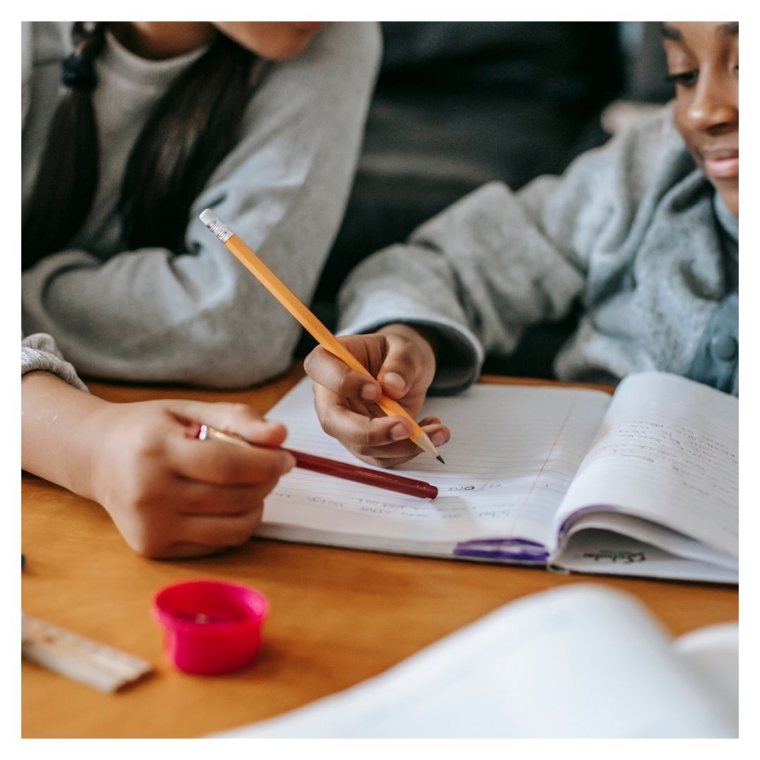 kid working on homework with a teacher in an after school program