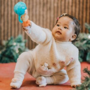 Baby Playing Indoors with Toy.